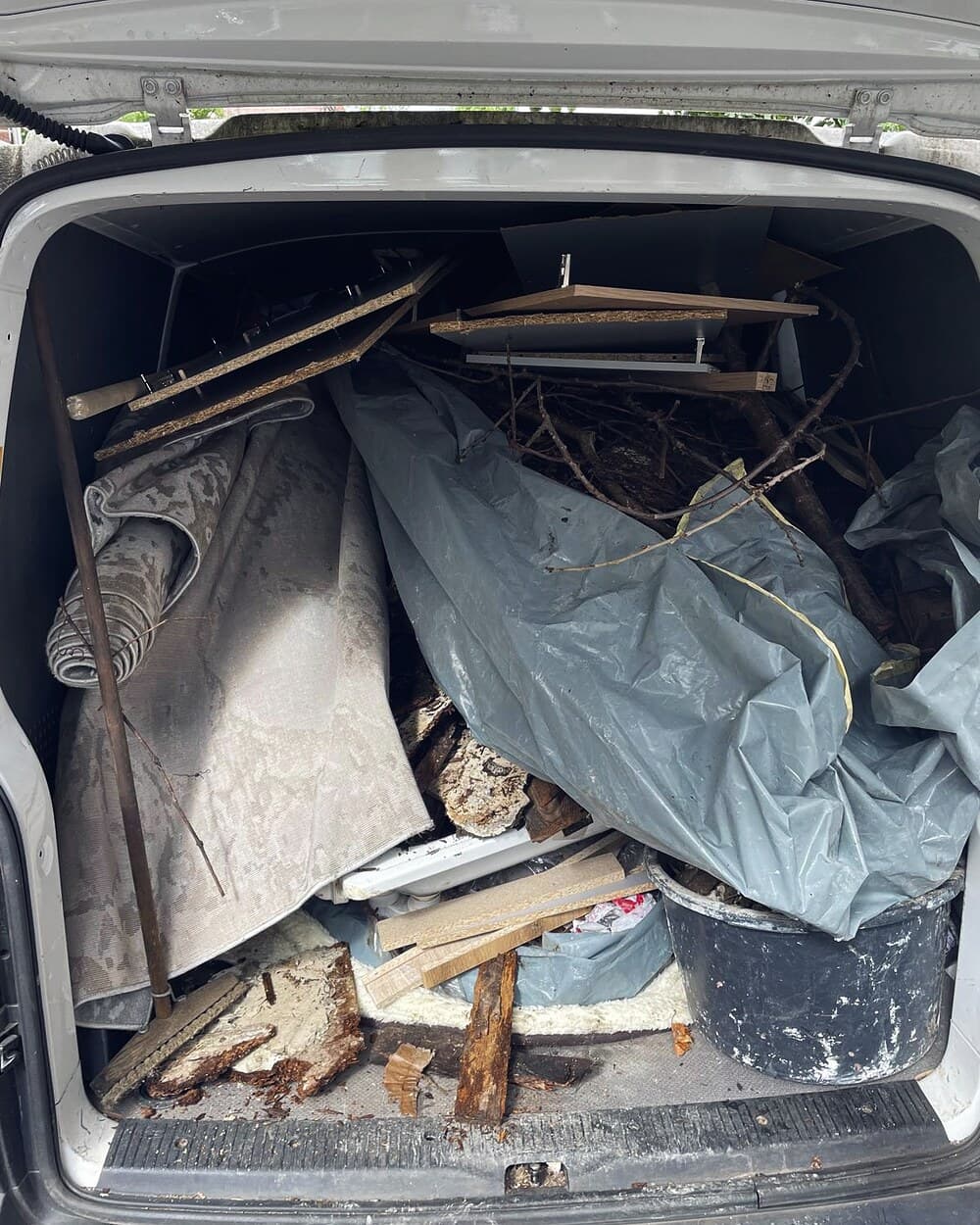 Bis unters Dach beladener Transporter mit Sperrmüll, Teppich und Bauschutt nach einer Entrümpelung